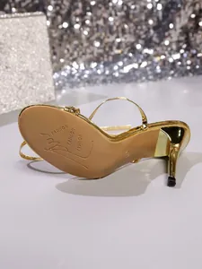 Close-up detail view of the gold high heel sandal sole and elegant stiletto heel