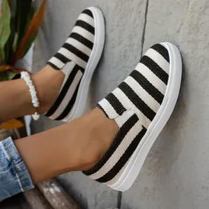 Detailweergave van modieuze zwart-wit gestreepte canvas instapschoenen voor dames