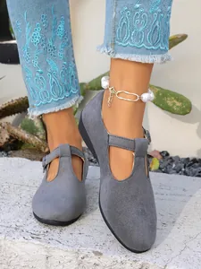 Dettaglio di ballerine Mary Jane in camoscio grigio con cinturino a T e jeans blu