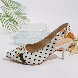 Vista detallada de los tacones slingback blancos a lunares con punta fina y hebilla metal