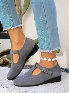 Vista dettagliata delle scarpe con zeppa Mary Jane in pelle scamosciata grigia con cinturino a T