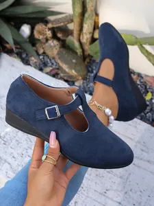 Dettaglio di scarpe con zeppa in pelle scamosciata blu navy con cinturino a fibbia