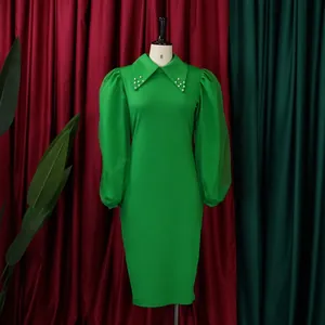 Detailed macro view of green pencil dress featuring pearl beaded collar and mesh puff sleeves