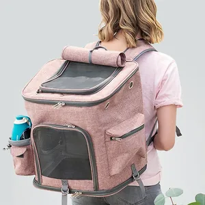Expandable pink pet backpack carrier for cats and small dogs being worn by a person outdoors