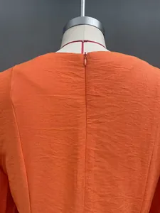 Back view detail of orange jumpsuit featuring smooth invisible zipper and textured fabric