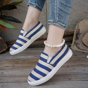 Casual blauw-beige gestreepte canvas instappers voor dames op een houten terras