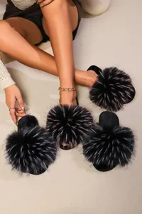 Close-up of multicolored plush fuzzy slides with large pom-poms for indoor wear