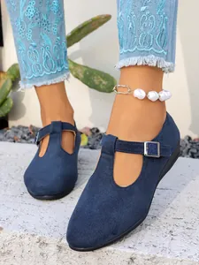 Vista dettagliata di scarpe con zeppa in camoscio blu navy con cinturino a T e fibbia regolabile