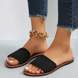 Vista detallada de sandalias planas para mujer con una tira de tela tejida negra casual