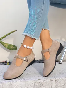 Dettaglio scarpe con zeppa in pelle scamosciata tortora con fibbia e punta tonda
