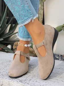 Vista dettagliata di scarpe con zeppa in pelle scamosciata kaki indossate da una modella