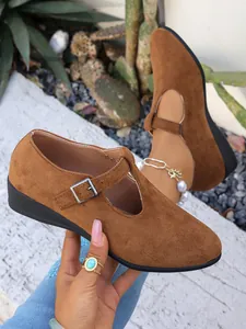 Dettaglio di scarpe Mary Jane da donna in camoscio marrone con elegante cinturino