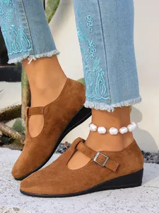 Vista dettagliata delle scarpe Mary Jane con zeppa in pelle scamosciata marrone