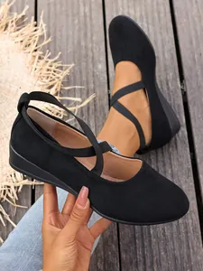 Dettaglio scarpe basse in camoscio nero da donna con cinturini elastici incrociati