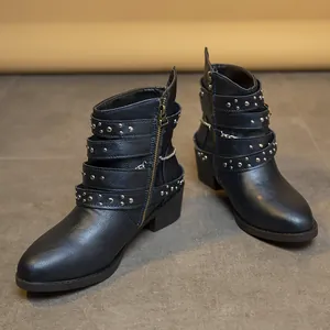 Vista detallada de botines punk para mujer con tachuelas metálicas y hebillas.