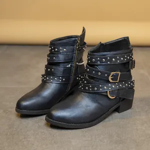 Vista de botines negros estilo punk con tachuelas plateadas y correas de hebilla.
