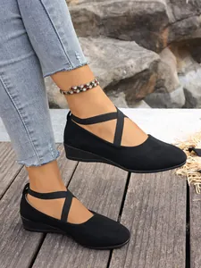 Scarpe con zeppa in pelle scamosciata nera con cinturini elastici incrociati.