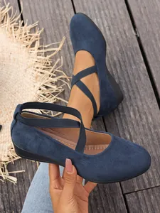 Vista dettagliata delle scarpe zeppa in camoscio blu scuro con cinturini elastici