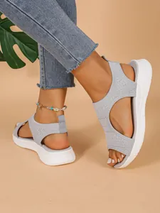 Nahaufnahme von grau gestrickten Plateausandalen für die Freizeit.