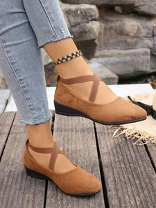 Vista dettagliata delle scarpe scamosciate marroni con cinturini elastici incrociati