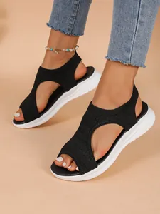 Bequeme schwarze Fly-Knit Mesh-Plateausandalen für Damen, am Fuß mit Jeans gezeigt