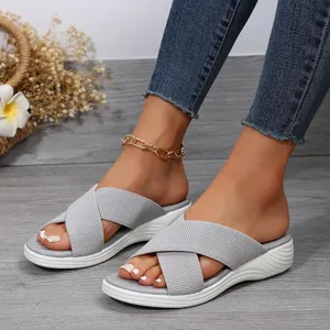 Close-up detail of grey woven cross straps and white textured platform sole on sandals