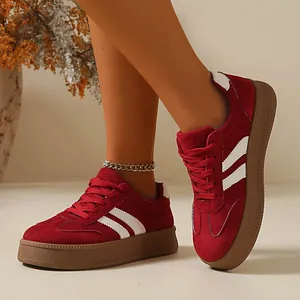 Detailed close-up of retro wine red suede platform sneakers featuring white side stripes.