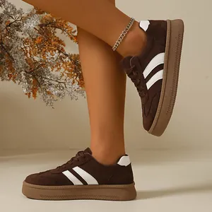 On-foot view of women's vintage brown suede sneakers with three white stripes.