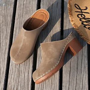 Mules à talons épais kaki pour femmes avec coutures contrastées sur un pont en bois