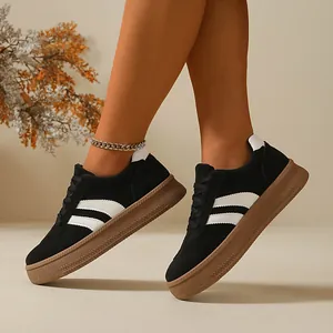 Detailed view of black and white retro German trainers with brown gum soles.