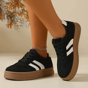 Close-up of black retro GAT sneakers with white stripes and brown gum platform sole