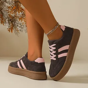 Close-up of gray and pink retro sneakers on feet with brown gum soles