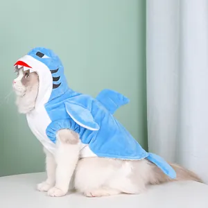 Detailed side view of a cat wearing a blue plush shark costume with fins and teeth