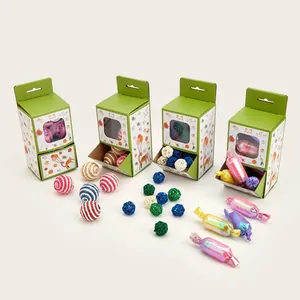 Display dettagliato di scatole regalo per gatti con palline di lana e caramelle.