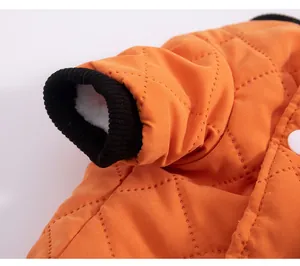 Close-up of orange quilted pet vest sleeve showing black ribbed cuff and fleece lining
