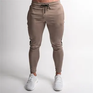 Close-up of men's slim fit athletic joggers featuring side stripes and drawstring