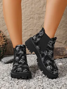 Detalle de botines Chelsea negros para mujer con estampado de mariposas y suela gruesa