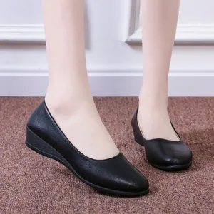 Elegant black soft leather pointed toe wedge shoes for women on a textured rug