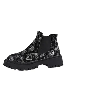 Botines Chelsea negros con suela track y un elegante estampado de mariposas blancas