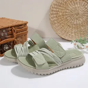 Vista detallada de sandalias de playa verde salvia con velcro y suela gruesa beige.