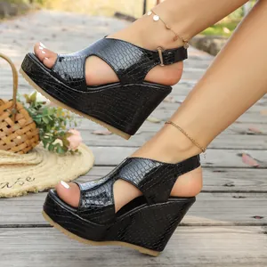 Zijaanzicht detail van zwarte sleehak sandalen met krokodillenmotief en enkelbandje