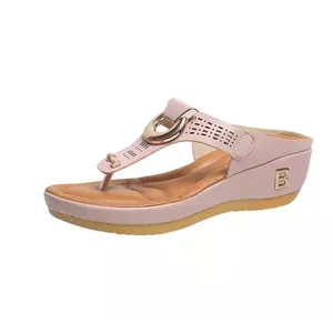 Vista lateral elegante de sandalias con cuña rosas y detalle de logotipo B metálico
