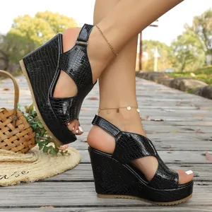 Detailweergave van stijlvolle zwarte sleehak sandalen met krokodillenprint en open teen
