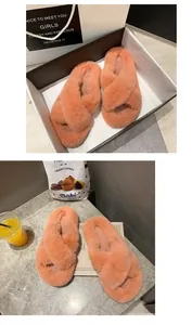 Vue détaillée de pantoufles pelucheuses orange dans un coffret cadeau et décor.