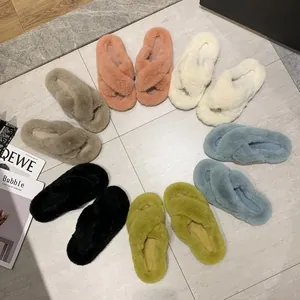 Pantoufles à plateforme en fausse fourrure avec brides croisées de couleurs vives.