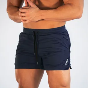 Detail of men's navy blue quick-dry gym shorts with drawstring waist and logo