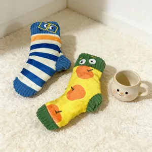 Vue détaillée de chaussettes en peluche colorées pour animaux sur un tapis blanc