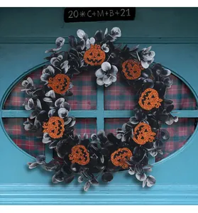 Close-up of black Halloween wreath with glitter orange pumpkin ornaments on a blue door.