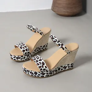 Close-up detail of stylish leopard print wedge sandals with platform sole and woven heel texture