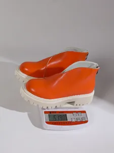 Weight measurement of stylish orange chunky platform ankle boots on an electronic scale